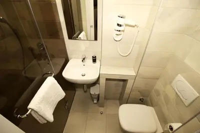 a white bathroom with a sink and a toilet at Passion Downtown Suite in Belgrade