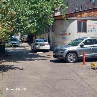 two cars parked in a parking lot next to a building at Passion Downtown Suite in Belgrade