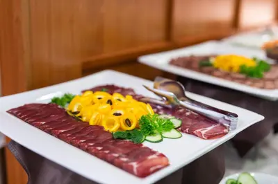 a plate of food with sausages and other foods at Hotel M in Belgrade