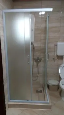 a shower stall in a bathroom with a toilet at Djurdja Apartment in Arandjelovac