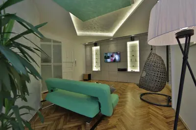a living room with a blue couch and a lamp at Apartment Alek in Belgrade