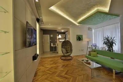 a living room with a green couch and a table at Apartment Alek in Belgrade