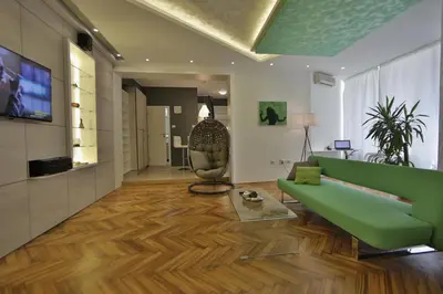 a living room with a green couch and a television at Apartment Alek in Belgrade