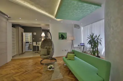 a living room with a green couch and a chair at Apartment Alek in Belgrade