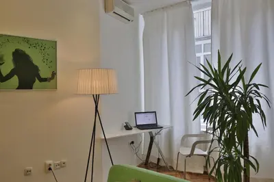 a living room with a laptop on a table and a plant at Apartment Alek in Belgrade