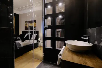 a bathroom with a sink and a bedroom at Ben Akiba Luxury Suites in Belgrade