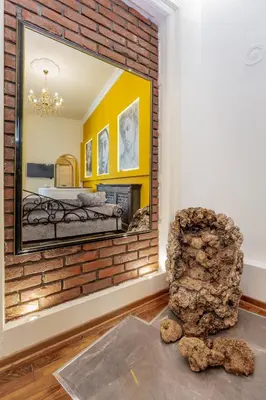 a mirror on a brick wall in a room with a chair at Ben Akiba Luxury Suites in Belgrade