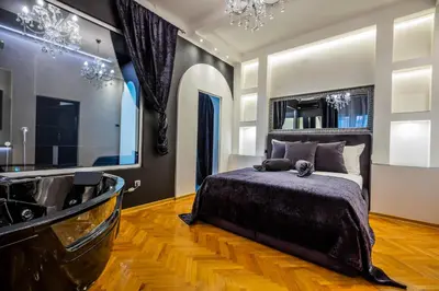a bedroom with a large bed and a tub at Ben Akiba Luxury Suites in Belgrade