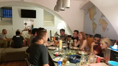a group of people sitting around a table eating at Balkan Soul Hostel in Belgrade