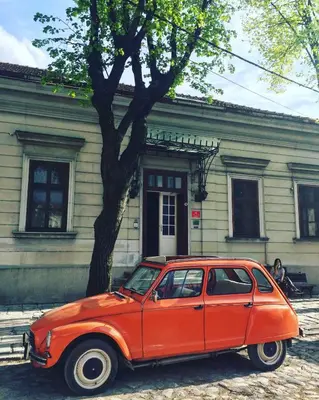 an orange car parked in front of a building at Balkan Soul Hostel in Belgrade