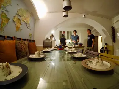 a group of people standing around a table with food at Balkan Soul Hostel in Belgrade
