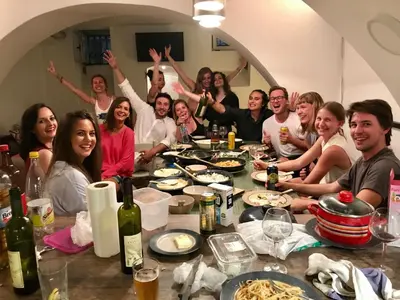 a group of people sitting around a table with food at Balkan Soul Hostel in Belgrade