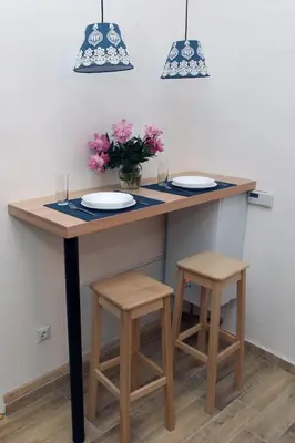 a table with two stools and two plates on it at Blue Box Apartment in Belgrade