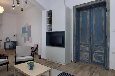 a living room with a tv and a door at Blue Box Apartment in Belgrade