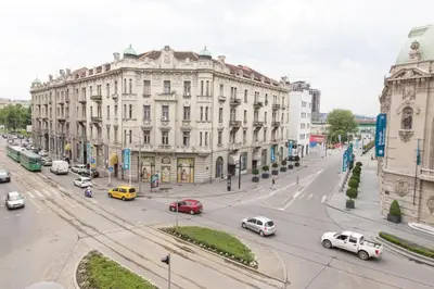 a busy city street with cars driving past a large building at Apartment Savamala 59 in Belgrade