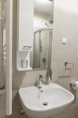 a bathroom with a white sink and a mirror at Apartment Savamala 59 in Belgrade