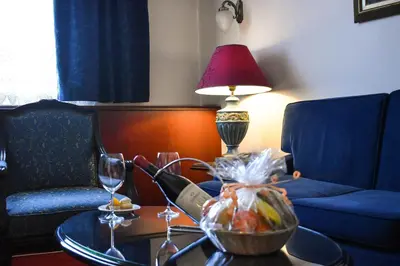 a room with a table with a bowl of fruit and a lamp at Palace Hotel in Belgrade