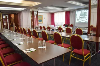 a conference room with long tables and red chairs at Palace Hotel in Belgrade