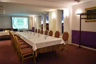 a conference room with a long table and chairs at Palace Hotel in Belgrade