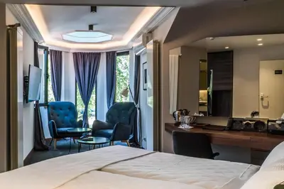 a hotel room with a bed and a desk and a mirror at Best Western Premier Natalija Residence in Belgrade