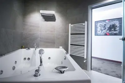 a bathroom with a bath tub and a sink at Best Western Premier Natalija Residence in Belgrade