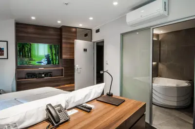 a bedroom with a bed and a telephone and a tub at Best Western Premier Natalija Residence in Belgrade