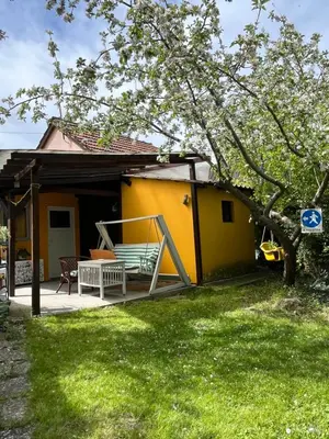 a yellow house with a porch with a bench at Charming Vacation House in Belgrade