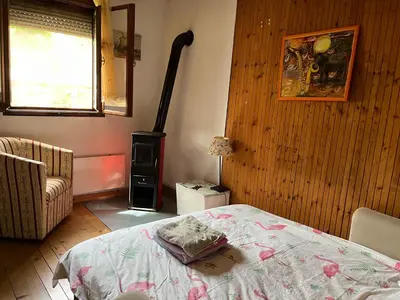 a room with a bed and a wood stove at Charming Vacation House in Belgrade