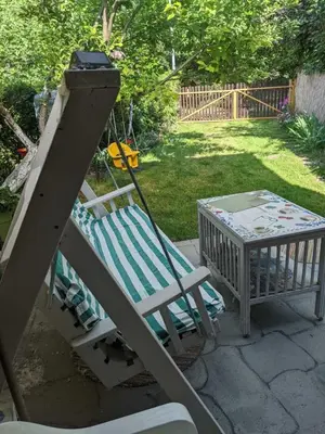 a porch with a swing and a table at Charming Vacation House in Belgrade