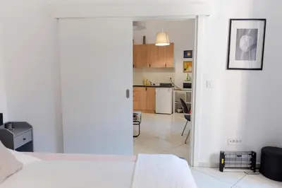 a white room with a bed and a kitchen at Apartment Luna Terazije in Belgrade