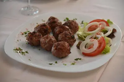 a plate of food with meatballs and salad on a table at B&B Park in Sremčica