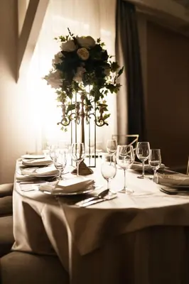 a table with wine glasses and a vase with flowers at B&B Park in Sremčica