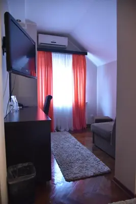 a living room with a flat screen tv and a window at B&B Park in Sremčica