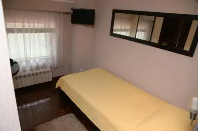 a small bedroom with a bed and a mirror at B&B Park in Sremčica