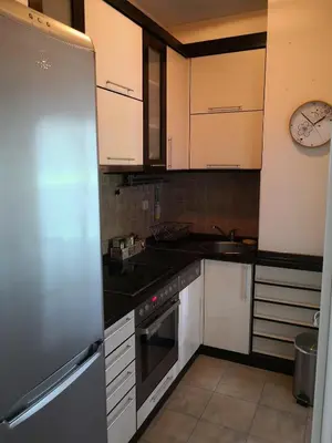 a kitchen with white cabinets and a stainless steel refrigerator at Ana's Apartment in Belgrade
