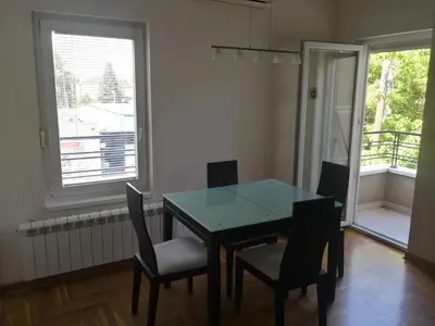 a dining room with a table and chairs and a window at Ana's Apartment in Belgrade