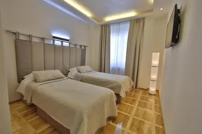 a room with two beds and a flat screen tv at Aber Apartment in Belgrade