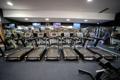 a gym with a row of treadles and monitors at Ring Inn Apartments in Obrenovac