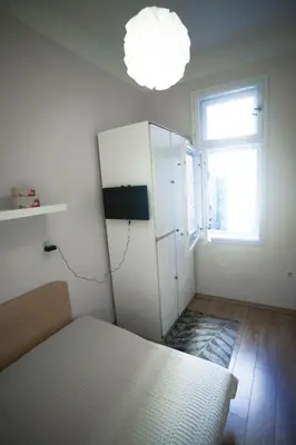 a bedroom with a white refrigerator and a window at Apartment Charlie PERFECT PRICE in Belgrade