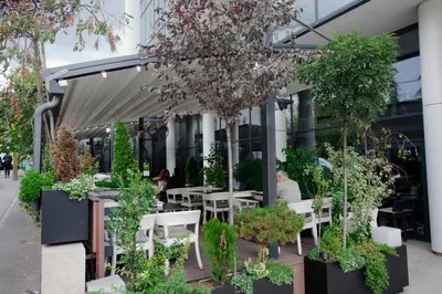 a restaurant with tables and chairs and plants at Apartment Charlie PERFECT PRICE in Belgrade