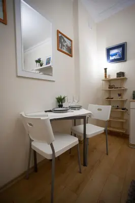 a dining room table with white chairs and a mirror at Apartment Charlie PERFECT PRICE in Belgrade
