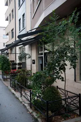a fence in front of a building with a tree at Apartment Charlie PERFECT PRICE in Belgrade