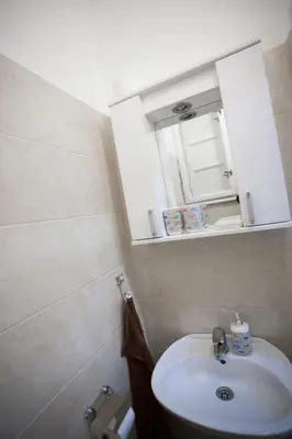 a bathroom with a white sink and a cabinet at Apartment Charlie PERFECT PRICE in Belgrade