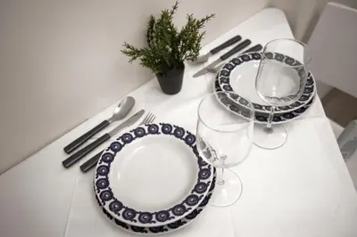 a white table with two plates and a wine glass at Apartment Charlie PERFECT PRICE in Belgrade