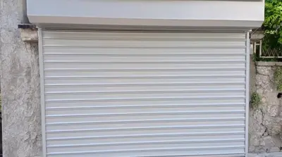 a white garage door on the side of a building at Belgrade Apartment Happy Garden in Belgrade