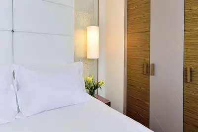 a bedroom with a white bed with white pillows at Belgrade Art Hotel, a member of Radisson Individuals in Belgrade