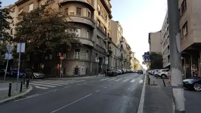 an empty city street with cars parked on the street at Apartment Elza in Belgrade