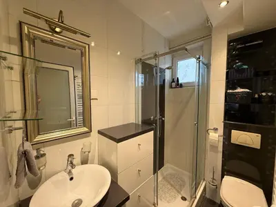 a white bathroom with a sink and a shower at Apartment Elza in Belgrade