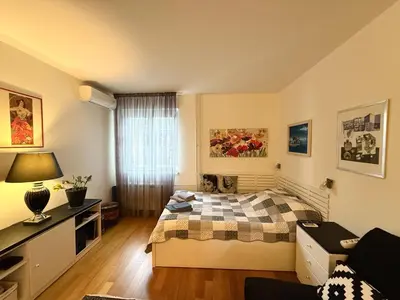 a bedroom with a bed and a desk and a window at Apartment Elza in Belgrade
