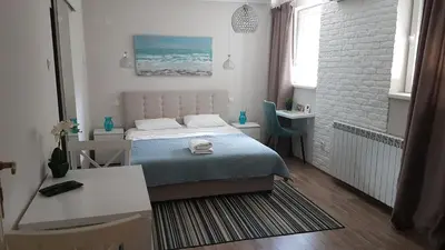 a small bedroom with a bed and a desk at Apartment Cherry Queen in Belgrade